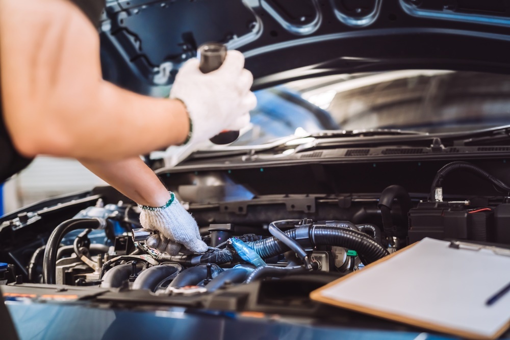 Auto technician inspecting a quality used engine under the hood