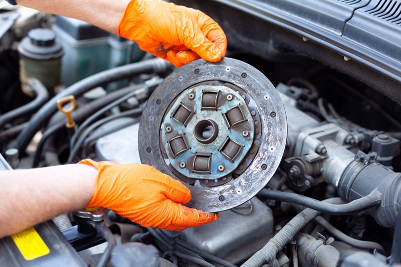 Mechanic inspecting a clutch disk from a transmission